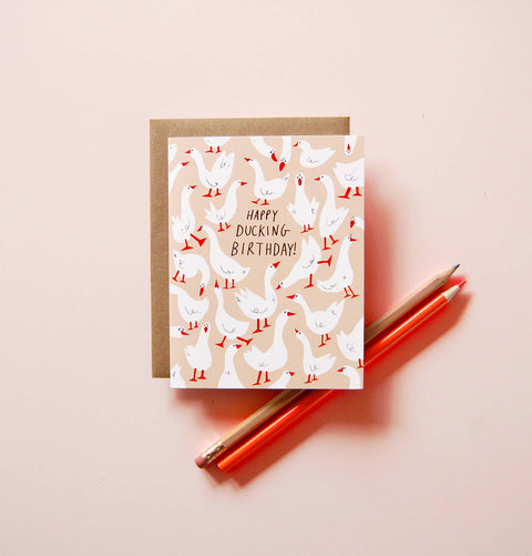 Greeting card with duck illustrations and 'Happy Ducking Birthday!' text on a light pink background.