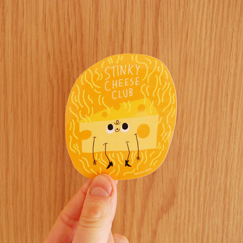Round sticker with cartoon cheese character and 'Stinky Cheese Club' text