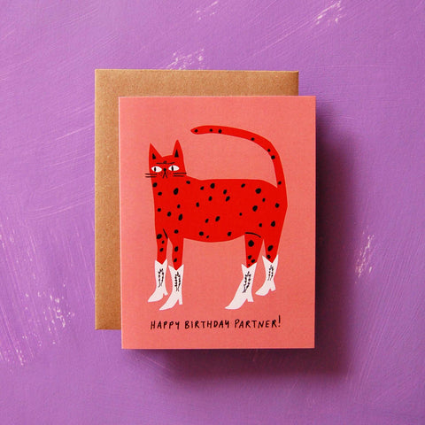 Greeting card with a red cat illustration and 'Happy Birthday Partner!' text on a pink background, against a purple textured background.