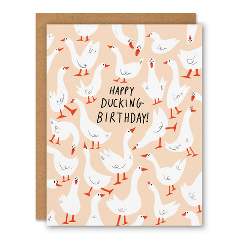 Greeting card with ducks and 'Happy Ducking Birthday!' text on a peach background