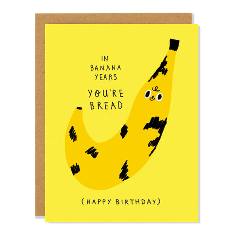 Birthday card with a banana illustration and humorous text on a yellow background "In banana years you're bread"