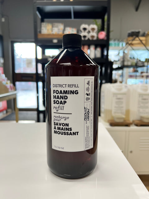 Bottle of District Refill foaming hand soap on a counter with a store background